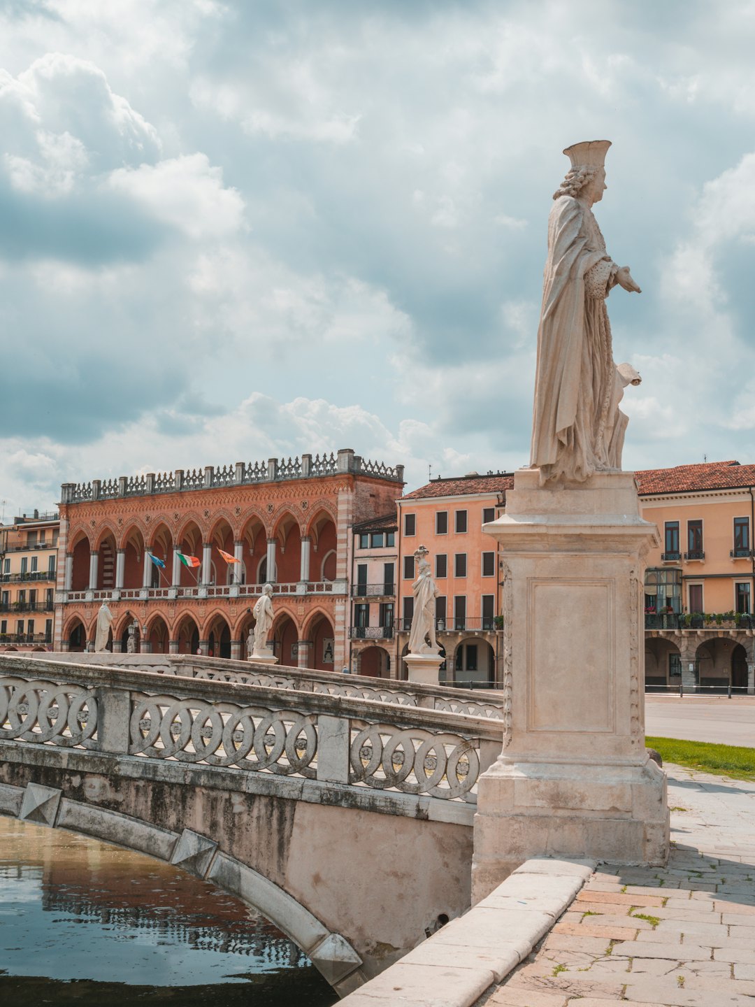 Palazzo in cotto ornato e ponte in pietra che si affacciano su un canale italiano.